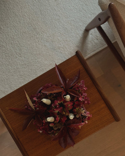 Moderner Adventskranz als minimalistisches Centerpiece – stilvolle Tischdekoration für den Winter in bordeaux rot